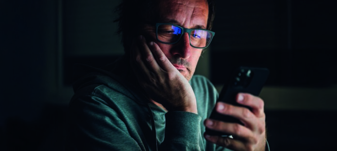 Idle,Bored,Male,Looking,At,Smartphone,Late,At,Night,,Browsing